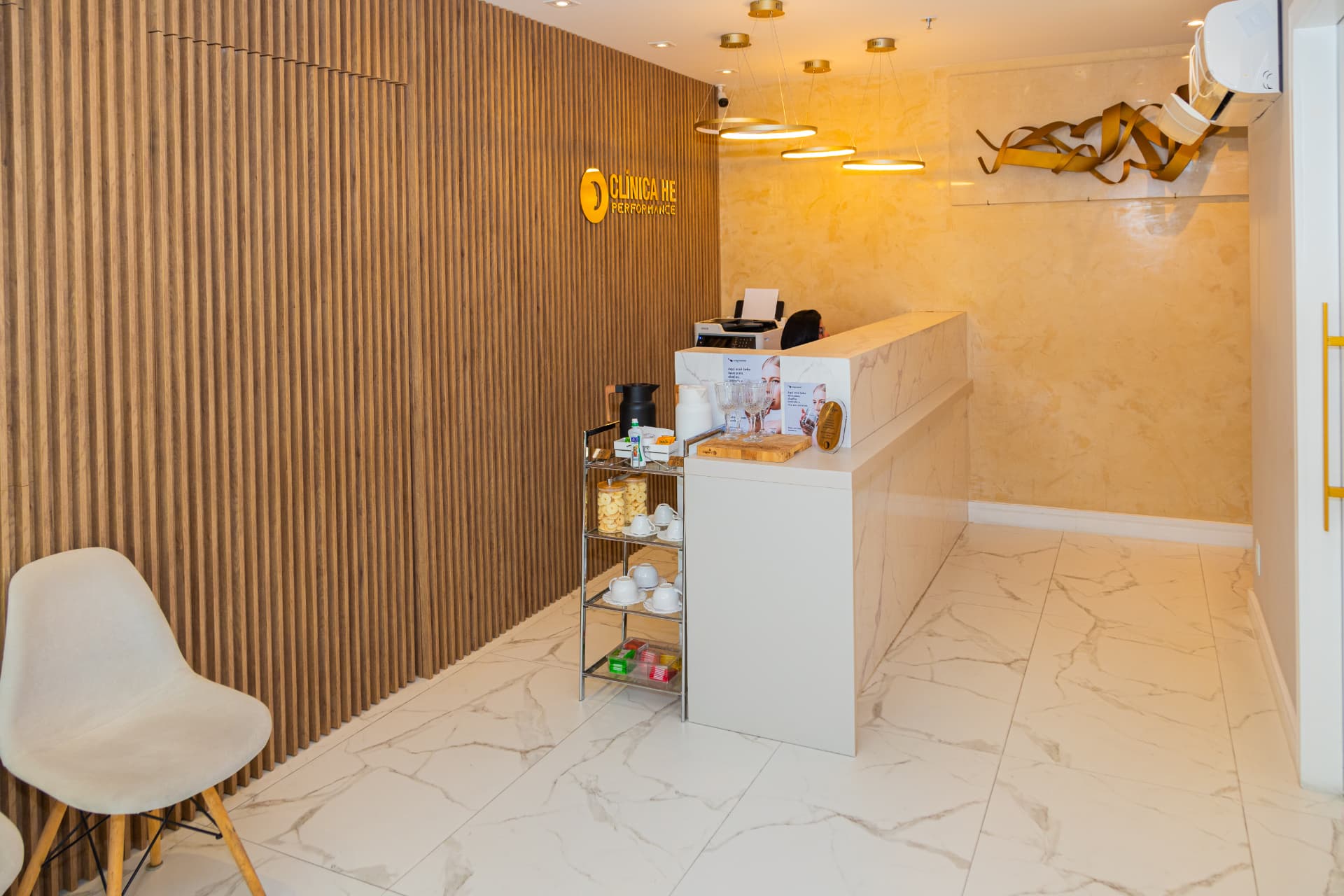 Detalhe do balcão de recepção e da parede em madeira ripada